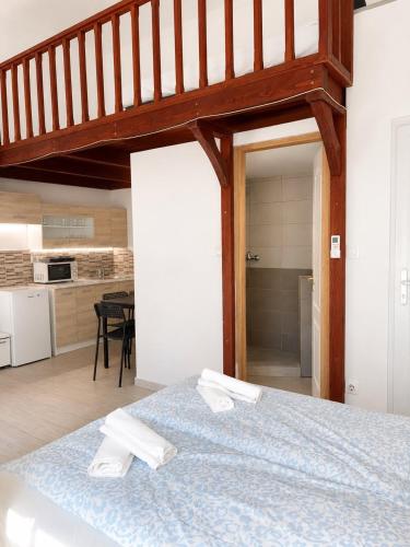 a bedroom with a bed with two white towels on it at Holdfény apartman in Siófok