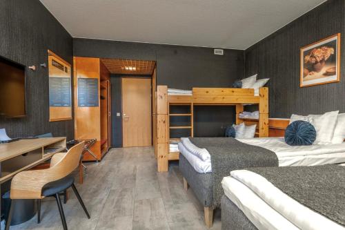a bedroom with two beds and a desk and a bunk bed at Hotelli Jämsä in Jämsä
