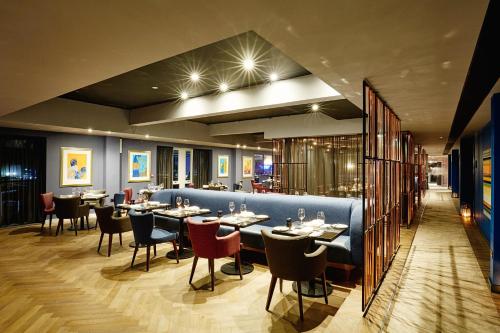 Un restaurante con mesas y sillas en una habitación. en Malmaison Brighton, en Brighton & Hove