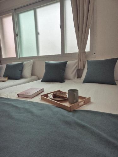 a large bed with a tray with a candle on it at 곁 Stay in Seoul