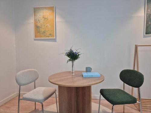 a table with chairs and a vase with flowers on it at 곁 Stay in Seoul