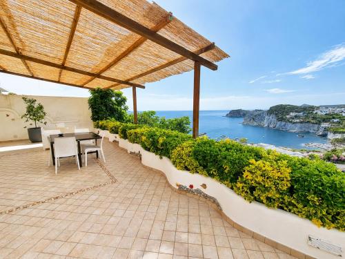 a patio with a table and chairs and the ocean at Maridea - La Procella in Ponza