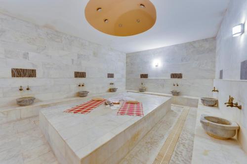 a large bathroom with a large tub and sinks at Bodrum Fora Holiday Resort in Bodrum City