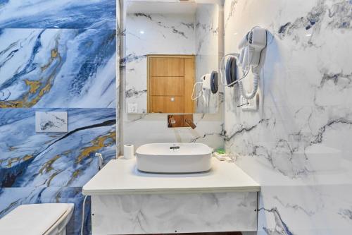 a bathroom with a white sink and a mirror at Hotel Saathviik99 in Tehri-Garhwāl