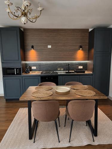 a kitchen with a wooden table and some chairs at Cabana Forest in Borşa