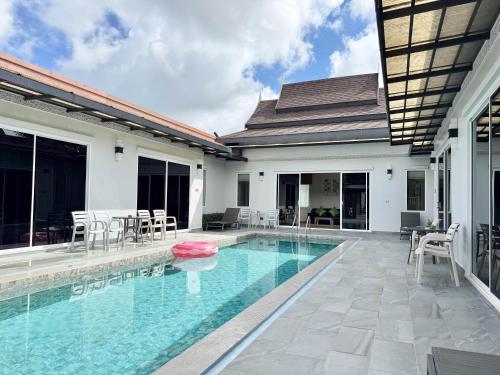 a swimming pool next to a villa at Phuket La Siesta, Naiharn Beach in Nai Harn Beach