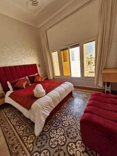 a bedroom with a large bed and a red couch at Riad Rabat Laalou in Rabat