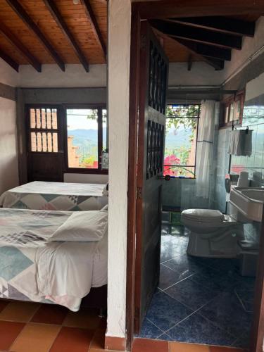 a bedroom with a bed and a bathroom with a sink at Villa Palosanto Campestre in Jericó