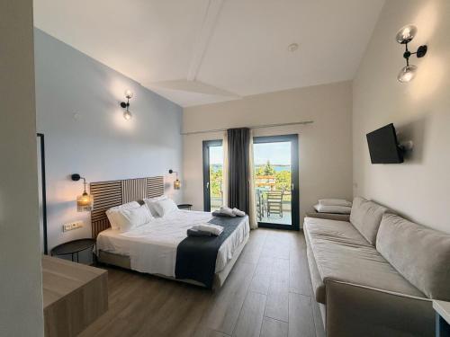 a bedroom with a bed and a couch at domus hospitality in Vourvourou