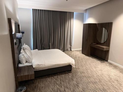 a hotel room with a bed and a mirror at شقق ثري ستار للشقق المخدومة 5 in Al Kharj