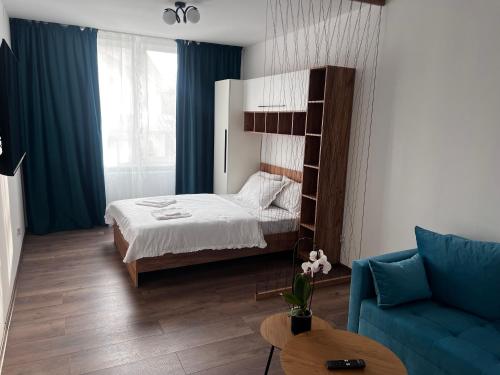 a bedroom with a bed and a blue couch at RUX Central Park in Petroşani