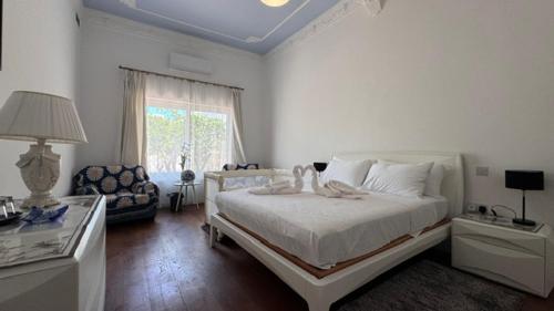 a white bedroom with a bed and a couch at Secret Villa - Room Lily in Taʼ Lampuka