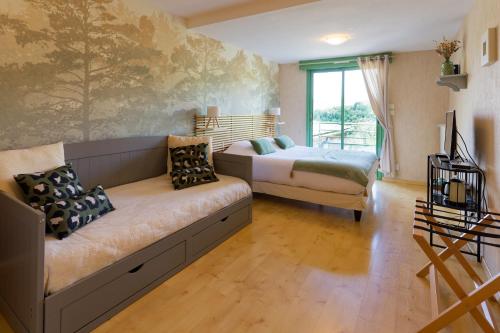 a bedroom with a couch and a bed and a window at Auberge du Fel in Le Fel