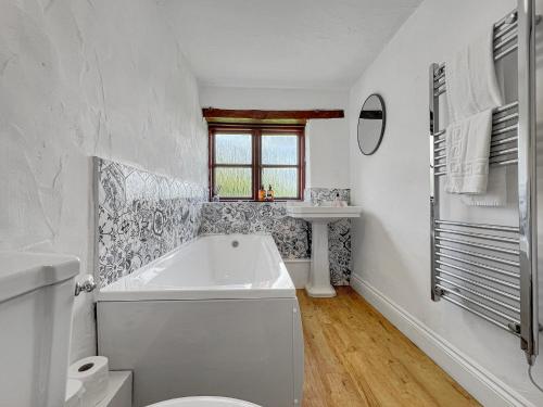 a white bathroom with a tub and a sink at Norton Cottage Hawkridge in Dulverton