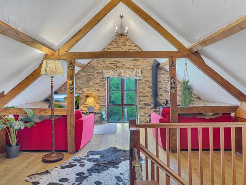 a living room with pink furniture and a stone wall at Norton Cottage Hawkridge in Dulverton