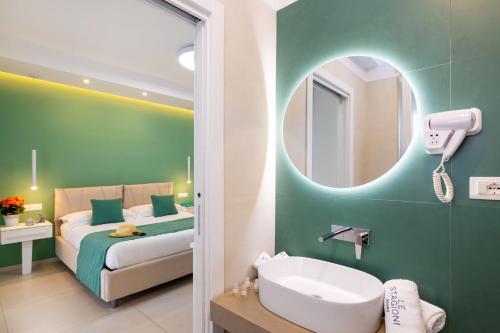 a bathroom with a bed and a sink and a mirror at Le Stagioni Rooms in Vieste