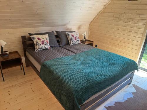a bedroom with a bed in a wooden room at Stodoła in Kamień