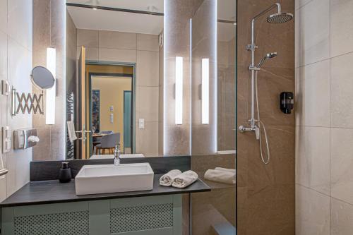 a bathroom with a sink and a shower at Szarvaskút Hotel in Zirc