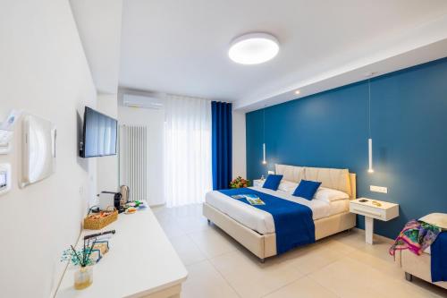 a hotel room with a bed and a blue wall at Le Stagioni Rooms in Vieste