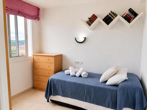 a bedroom with a bed with blue sheets and a window at Mediterranean Escape - Sea Views Pool in Malgrat de Mar