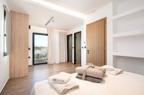 a white bedroom with two beds and a balcony at SoleLuna - The Villas Project in Marmaroto
