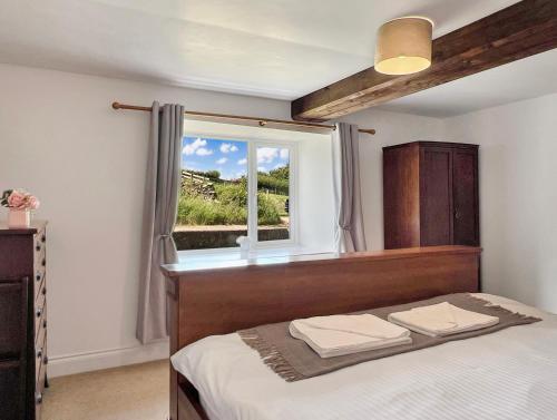 a bedroom with a bed and a window at Wingate Farm Countisbury in Countisbury