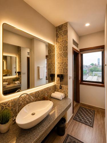 a bathroom with a sink and a large mirror at Dynasty Boutique Hotel in Phnom Penh