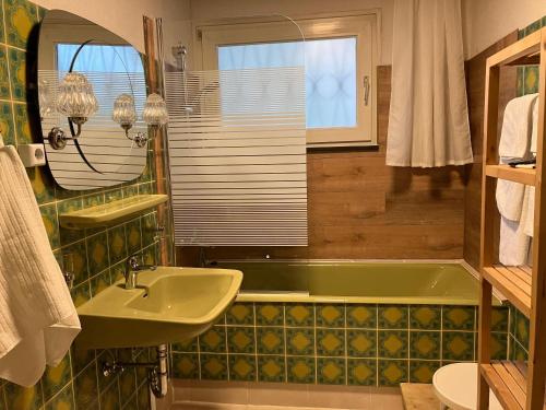 a bathroom with a green tub and a sink at Ferienhaus-in-idyllischer-Lage in Inning am Ammersee