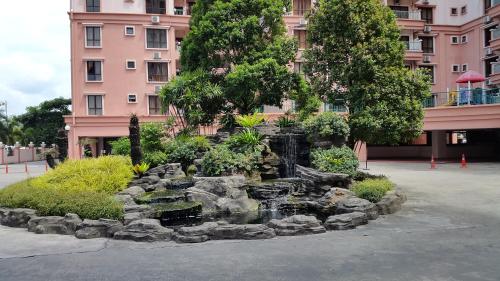 a garden in front of a building with a water fountain at Peter Holiday Home @ Marina Court Condo in Kota Kinabalu