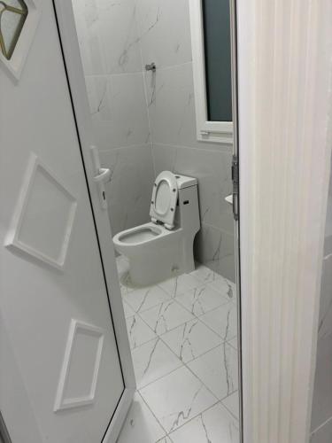 a white bathroom with a toilet and a mirror at منزل للإيجار اليومي in Ḩilf