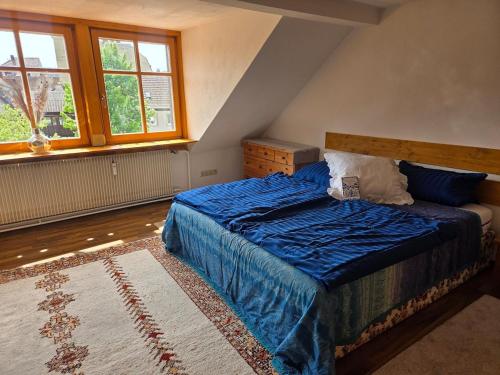a bedroom with a bed with a blue comforter at Ferienwohnung Saskia in Hammelburg