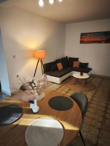 a living room with a table and a couch at Holiday Home Olivetree Rab in Supetarska Draga