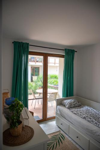 a bedroom with a bed and a sliding glass door at Apartament Roberto in Żarnowska