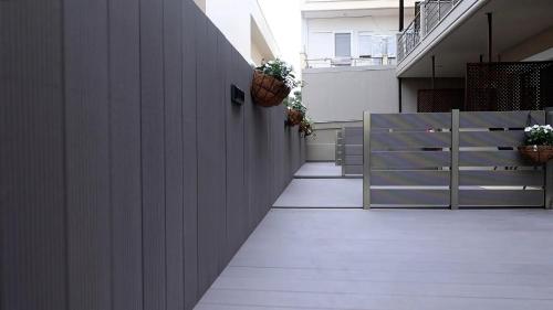 a hallway with a white wall with plants on it at NikolaosMare in Nea Potidaea