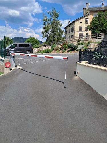 a barrier on a street with a car in the background at L'école des frères in Saint-Julien-Chapteuil