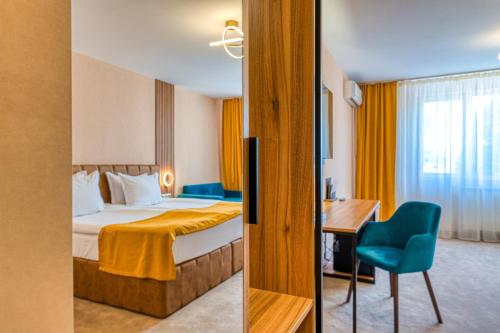 a hotel room with a bed and a desk at Hotel Montecito in Sofia