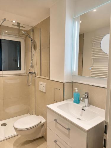 a bathroom with a sink and a toilet and a mirror at Steinweg 7 Ferienwohnung in Kassel
