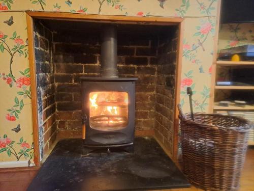 a wood stove in a room with a brick wall at Character Cottage in Wallingford in Wallingford