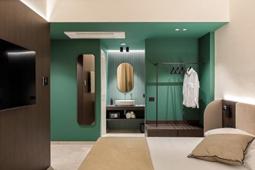 a bathroom with green walls and a sink and a mirror at Dimora degli archi in Terrasini