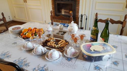 - une table avec 2 bouteilles de vin et quelques plats dans l'établissement Camden House, à Aubry-le-Panthou