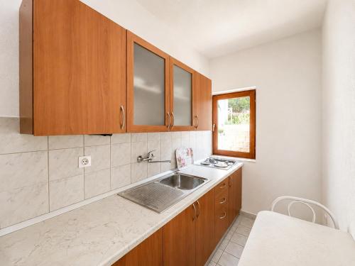 a kitchen with wooden cabinets and a sink at Apartments Marija Magdalena in Hvar