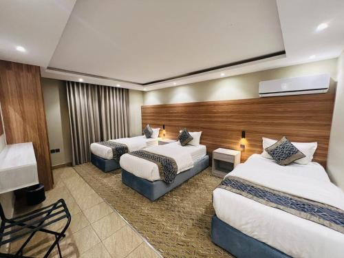 a hotel room with two beds and a couch at شقق سكنية بابو ذر in Medina
