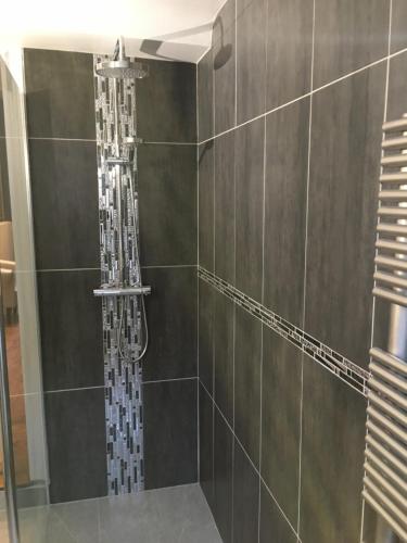 a shower with a shower head in a bathroom at Villa Des Ursulines in Bayeux