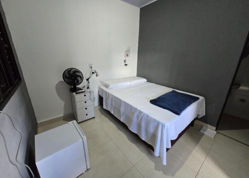 a bedroom with a white bed and a white dresser at Microcasa 6 in Lajeado