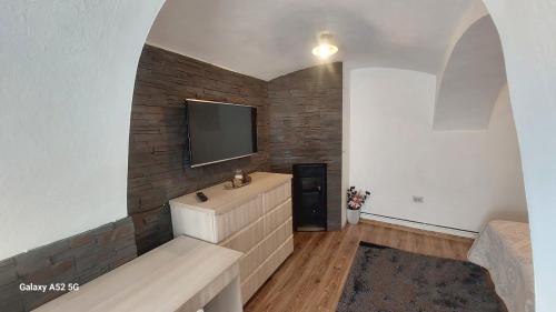 a living room with a tv on a brick wall at Casa Iacob in Sighişoara