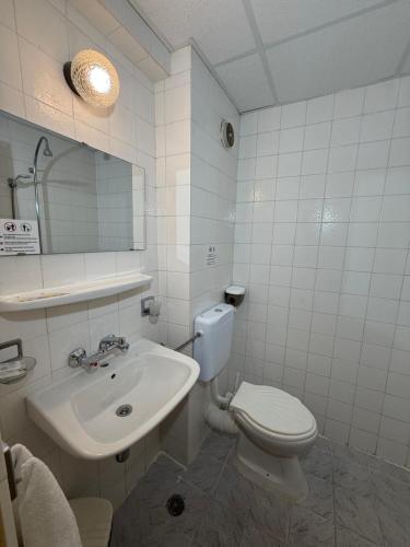 ein weißes Badezimmer mit Toilette und Waschbecken in der Unterkunft Hotel Olymp in Sonnenstrand