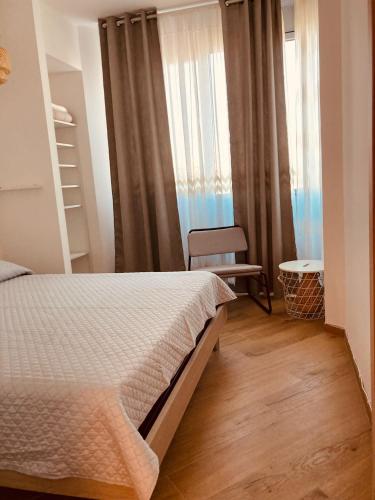 a bedroom with a bed and a chair and a window at Casa Di Luce con Parcheggio Privato Interno Gratuito in Montesilvano