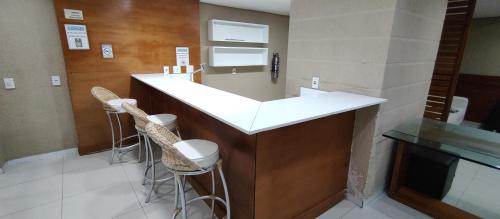 a bar with two stools and a counter in a room at Porto Real Resort - Leisure and Fun in Mangaratiba