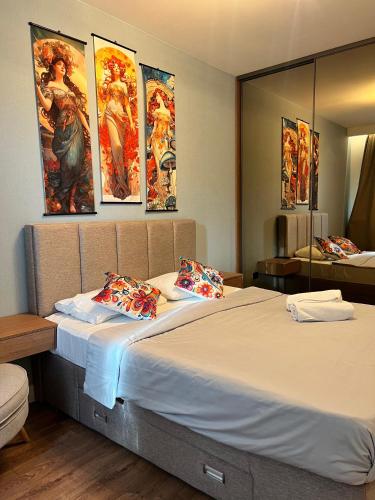 a bedroom with a large bed with paintings on the wall at Dreams house elia in Budva
