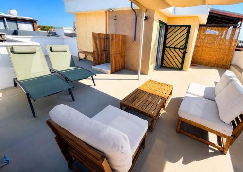 a balcony with a bed and chairs on a boat at Dune House in Ginosa Marina